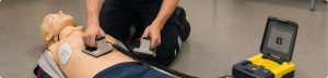 Utilisation d'un défibrillateur lors d'une formation aux premiers secours sur un mannequin de formation - Securinorme