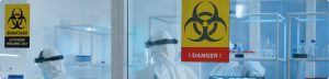 Laboratoire avec signalisation de danger biologique et opérateurs en combinaison de protection - Securinorme